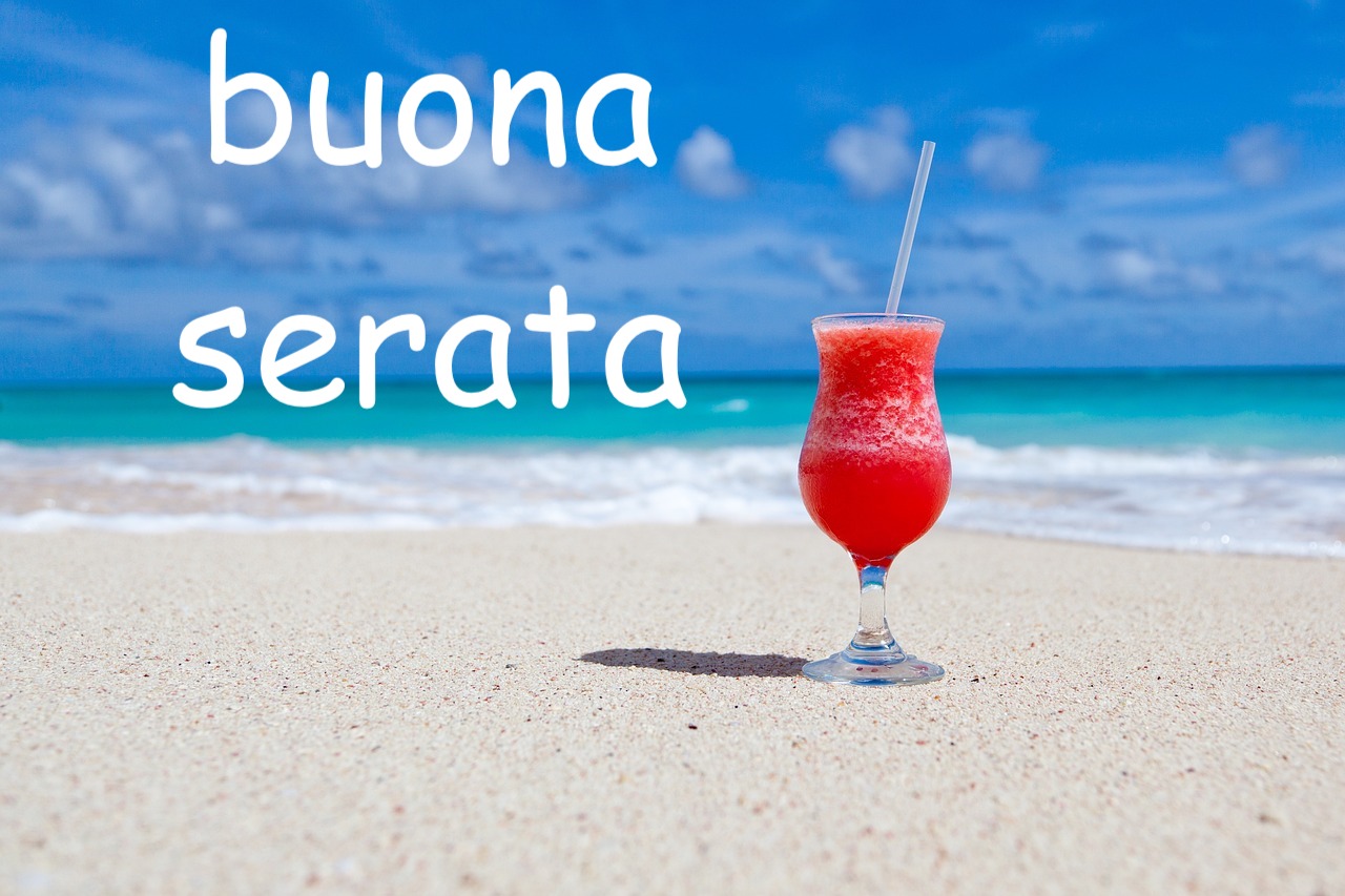 cocktail rosso su spiaggia e mare azzurro e smeraldino